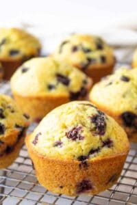 Muffins with berries on a baking rack.
