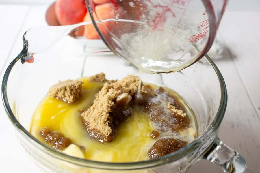 A glass bowl with brown sugar and melted butter.