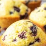Muffins filled with wild huckleberries on a baking rack.