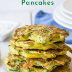 A stack of zucchini pancakes on a white board.
