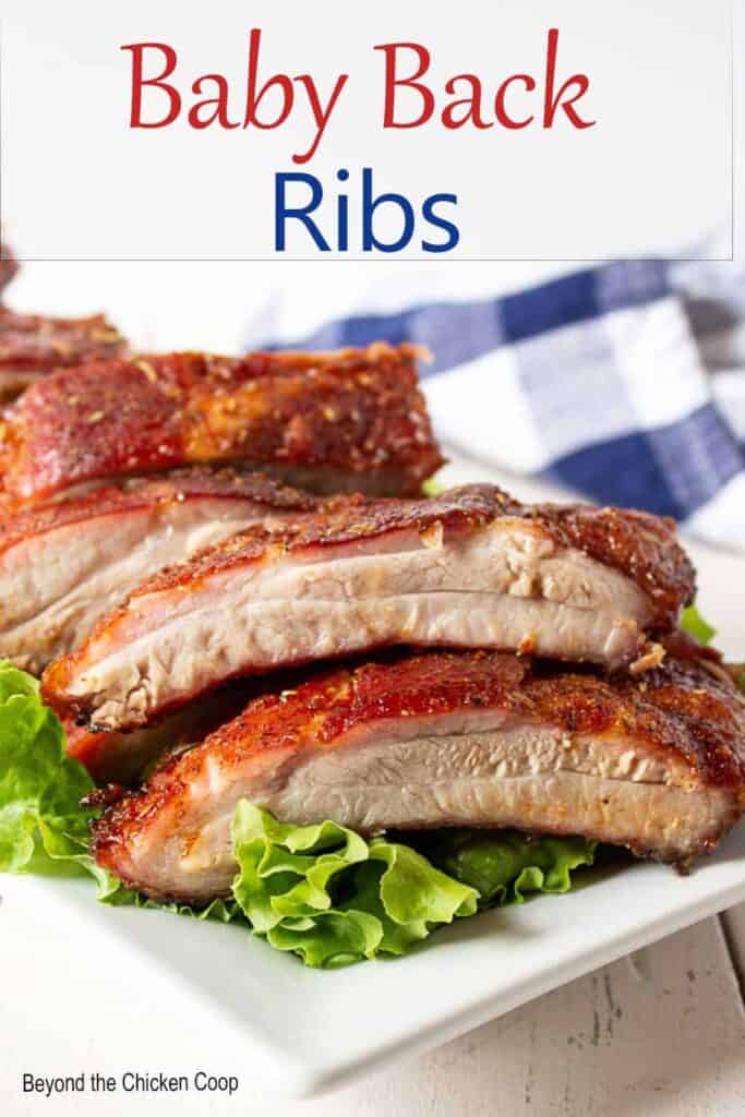A platter of baby back ribs on top of green lettuce.