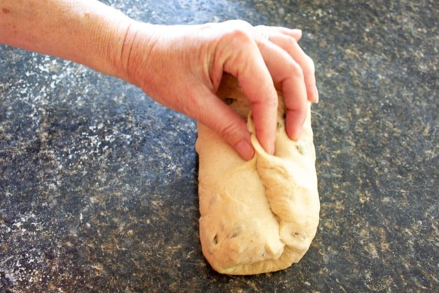 Forming bread dough into a log.