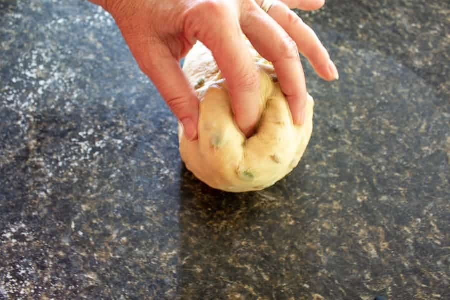 Tucking the ends into a round of bread dough.