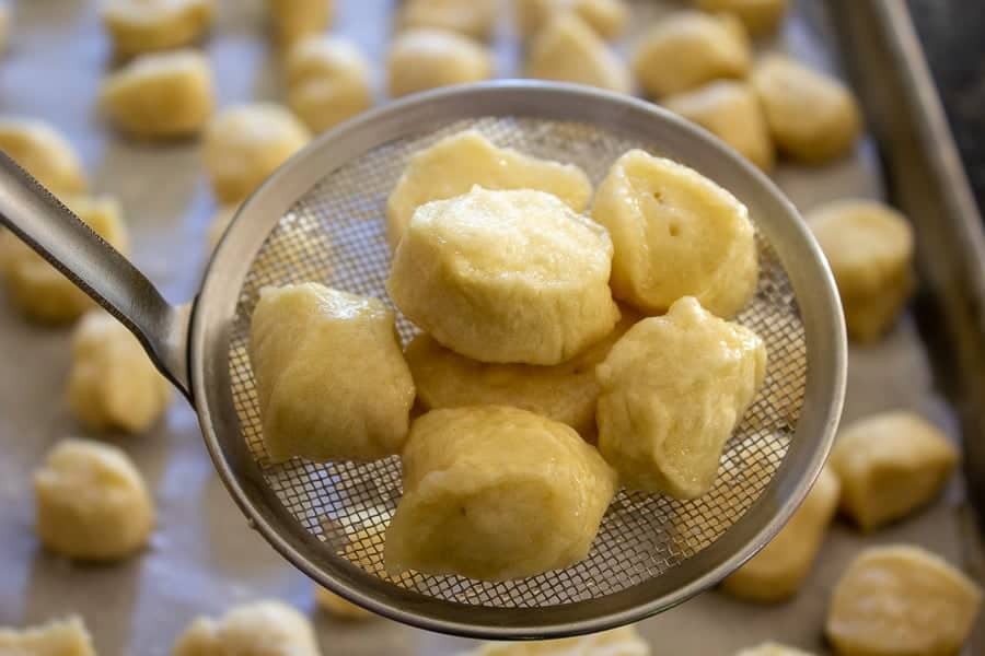 Boiled pretzels pieces on a sieve.