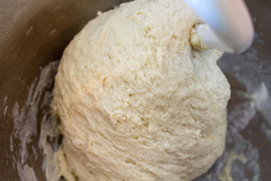 Bread dough forming a ball around a dough hook. 