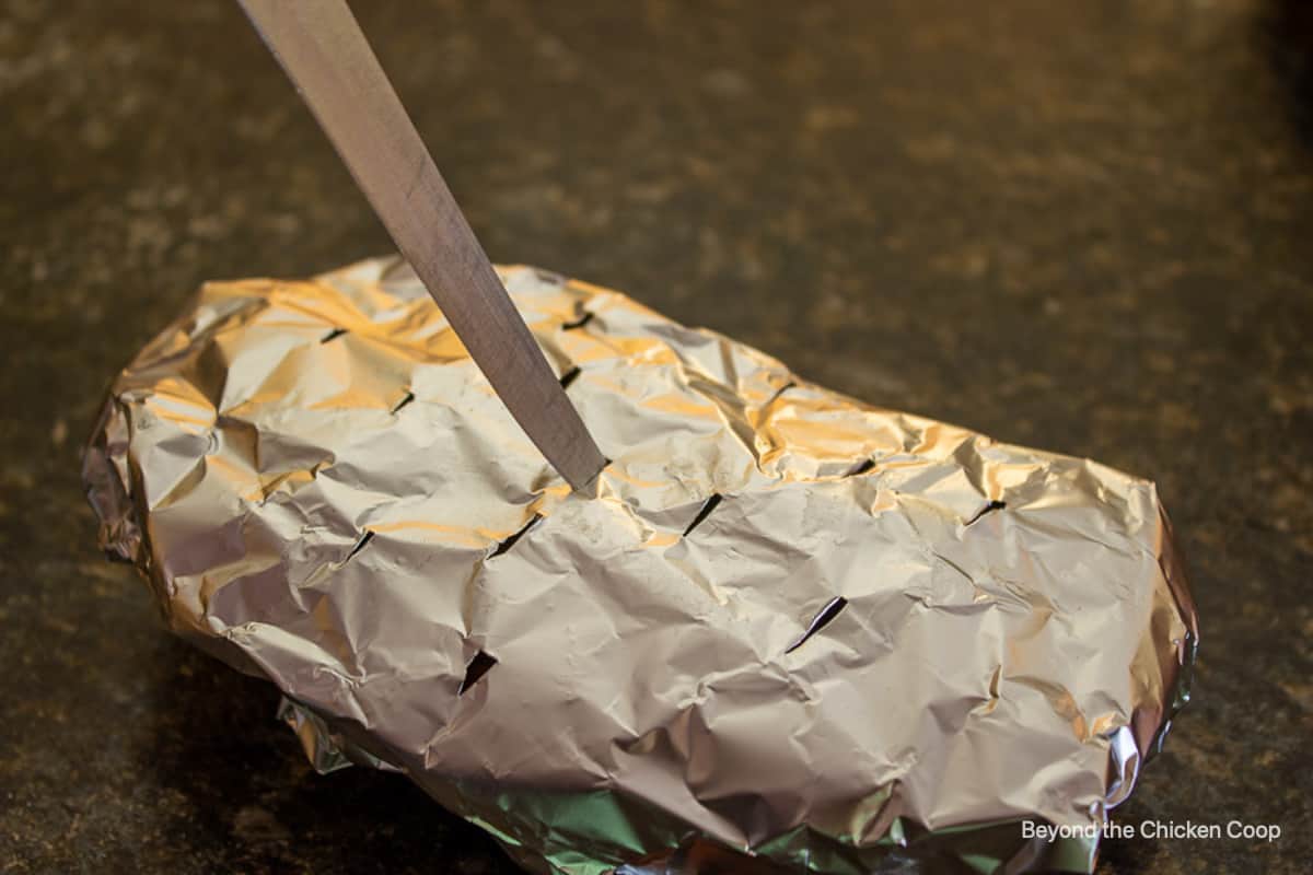 A foil packet with holes poked from a knife.