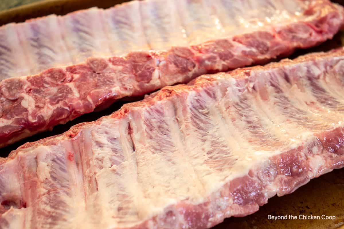 Pork ribs sitting on a baking sheet.