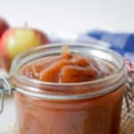 A glass jar filled with smooth apple butter.