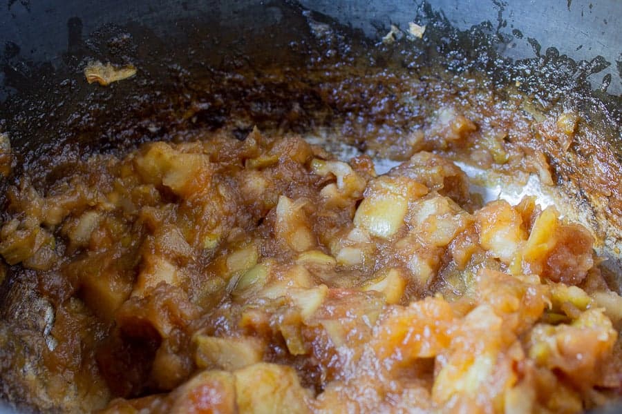 A crock pot full of cooked apples.