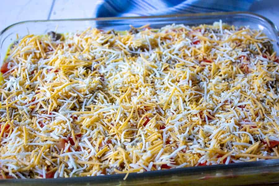 Grated cheese on top of an egg mixture. 