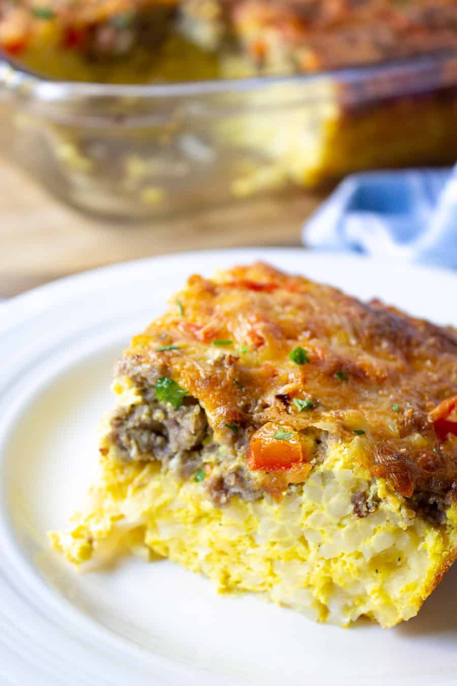 A slice of breakfast egg casserole on a white plate. 