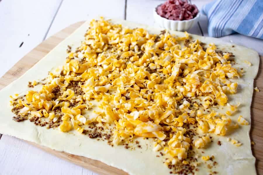 Puff pastry dough topped with grated cheese.