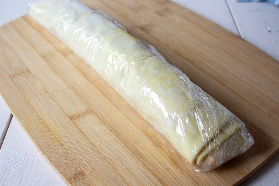 Puff Pastry log wrapped in plastic wrap.