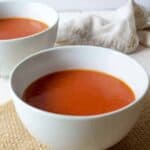 Two white bowls filled with soup.