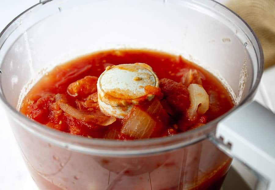 Cooked tomatoes and onions in a food processor.