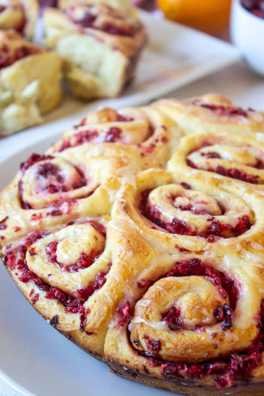 A plateful of freshly baked cinnamon rolls filled with chopped cranberries. 