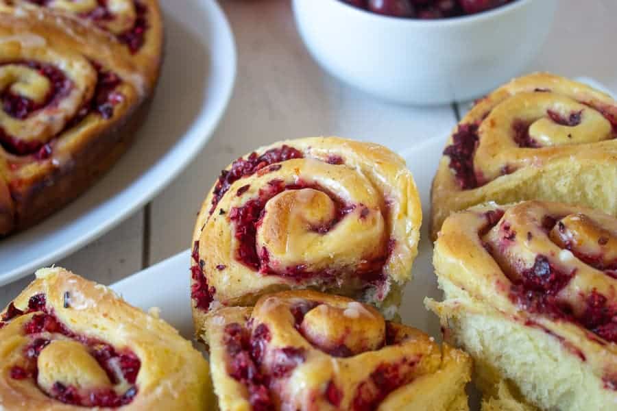 A white plate with cranberry sweet rolls. 