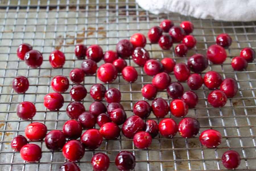 Shinny cranberries drying on a baking rack.