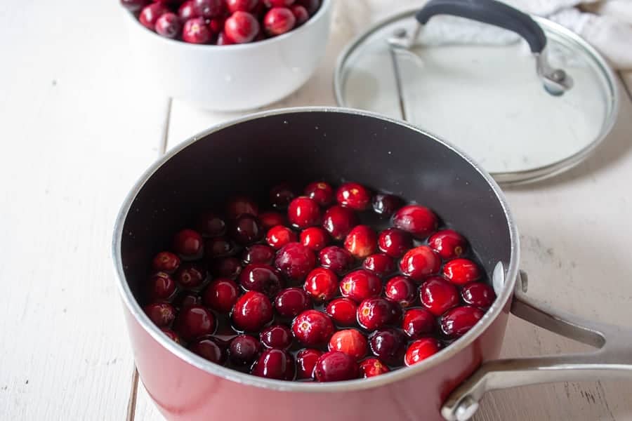 Fresh cranberries in a small red pot.