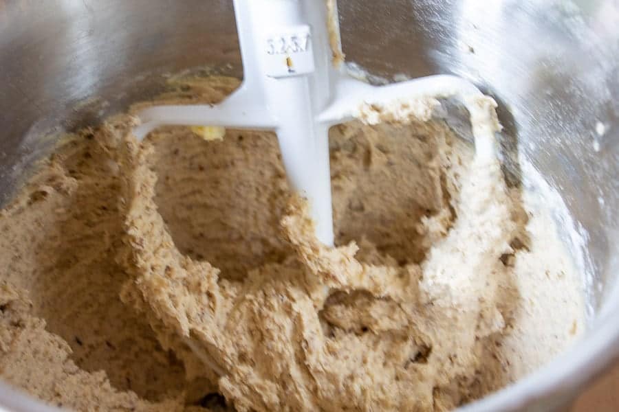 Cookie dough in a bowl with a paddle attachment.