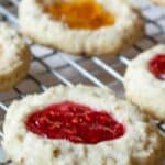 Jam filled cookies on a baking rack.