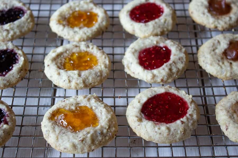 Jam filled cookies on a baking rack. 