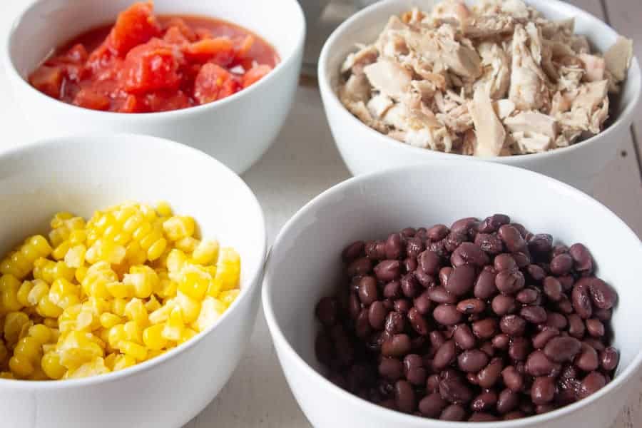 Bowls filled with black beans, corn, tomatoes and chopped turkey.