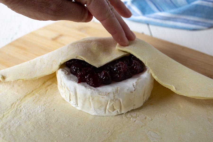 Brie topped with cranberries and puff pastry dough.