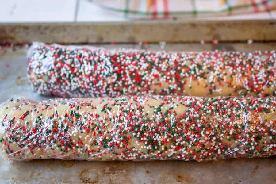 Cookie dough logs covered with colored sprinkles.