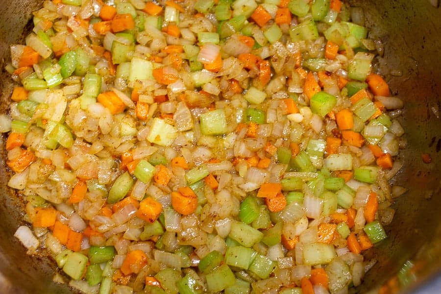 Cooked vegetables in a soup pot.