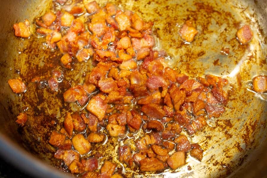 Cooked bacon bits in a pan.