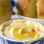 A small blue and white bowl filled with butter and honey.