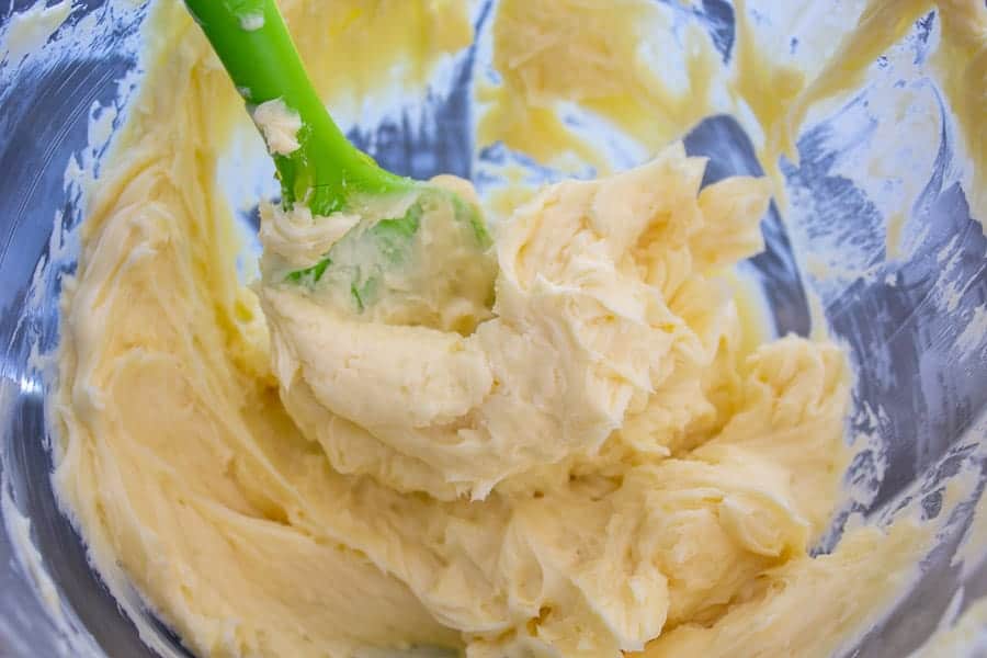 Whipped butter in a bowl with a green spatula.