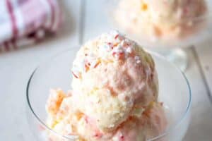 Scoops of pink swirled ice cream in a glass dish.