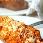 A baked sweet potato topped with parmesan cheese.