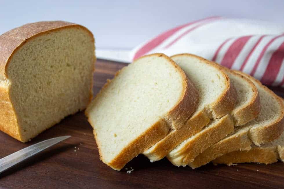 Slice bread on a wooden cutting board.