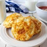 A plate filled with three cheesy biscuits.