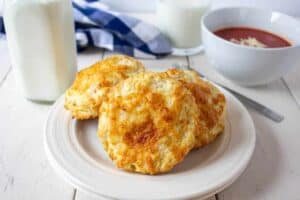 A plate filled with three cheesy biscuits.