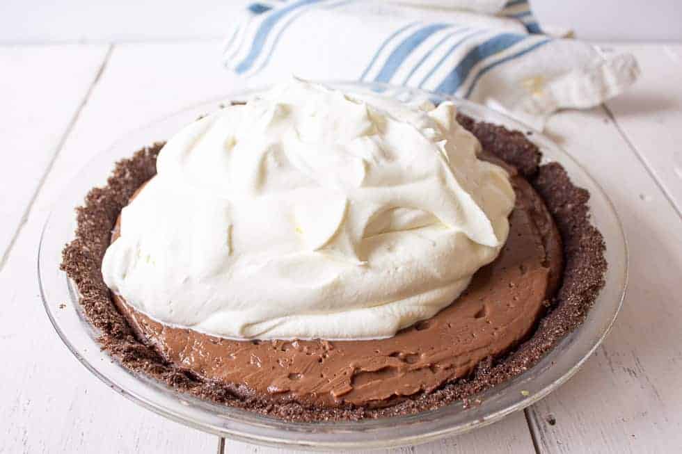 Whipped cream on top of a chocolate pie.