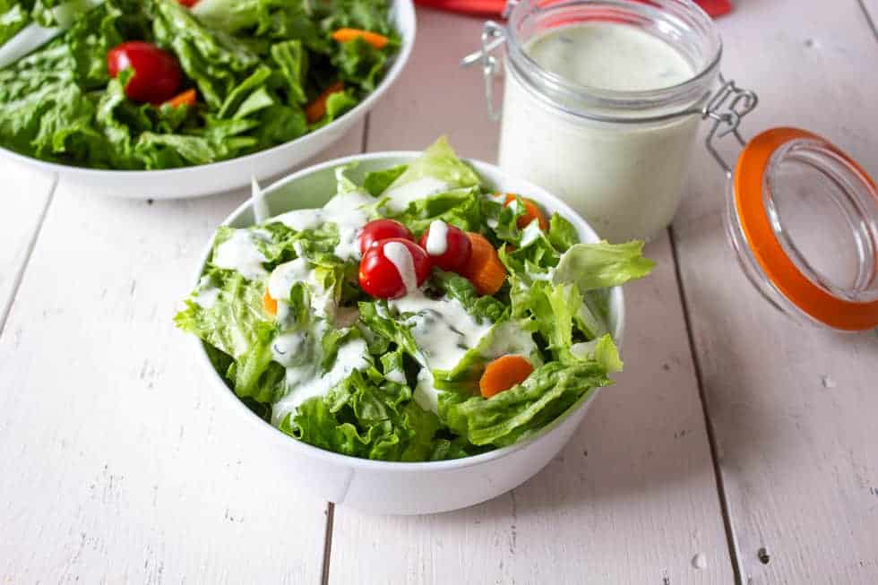 Green salad with tomatoes, onions and a creamy salad dressing. 