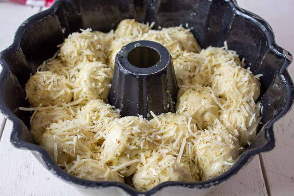 A bundt pan filled with round bread dough.