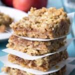 Four oat bars stacked with a piece of parchment paper between each bar.