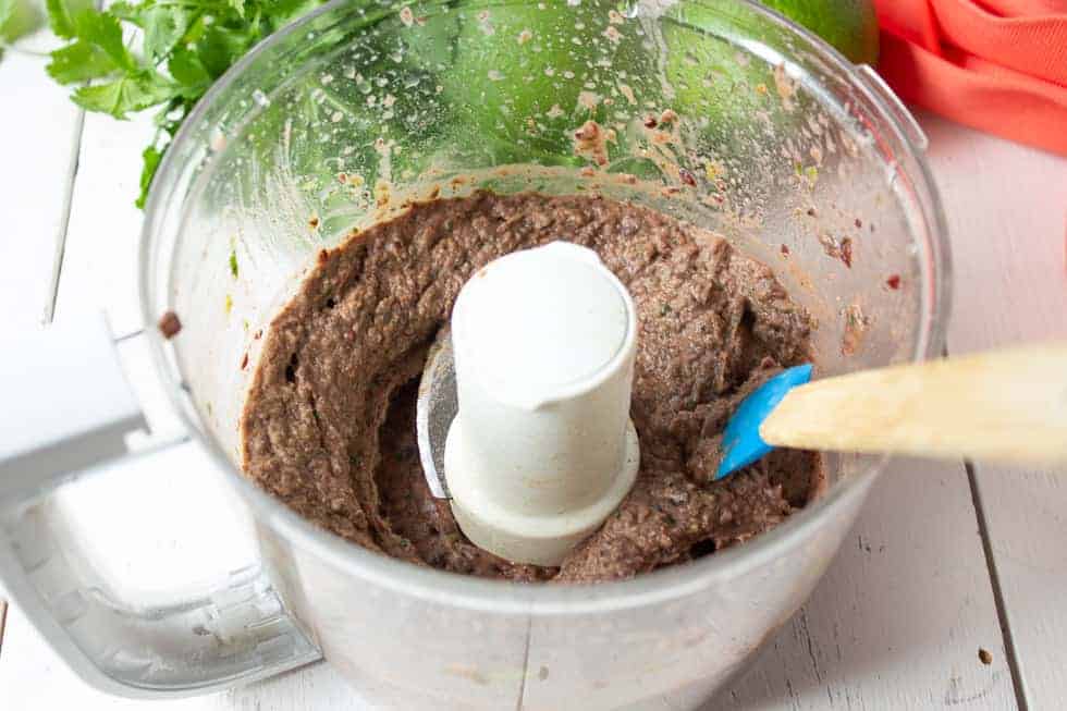 Pureed beans in a food processor bowl.