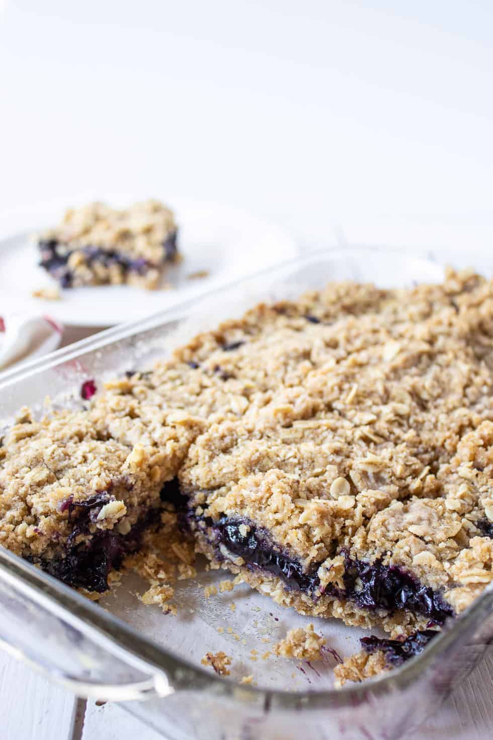 A glass dish filled with blueberry crumb bars.