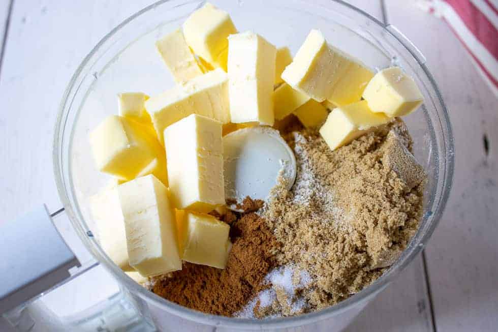 A food processor bowl filled with flour, butter and spices.
