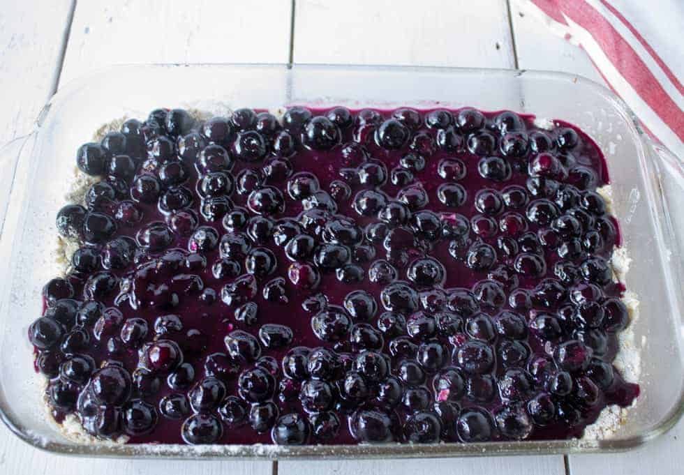 A layer of blueberry filling in a glass dish.
