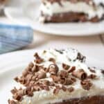 A slice of chocolate cream pie topped with whipped cream and chocolate shavings.