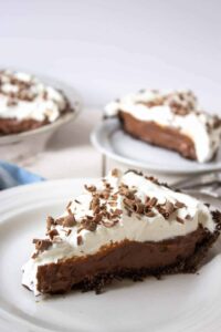A slice of chocolate pie topped with whipped cream.