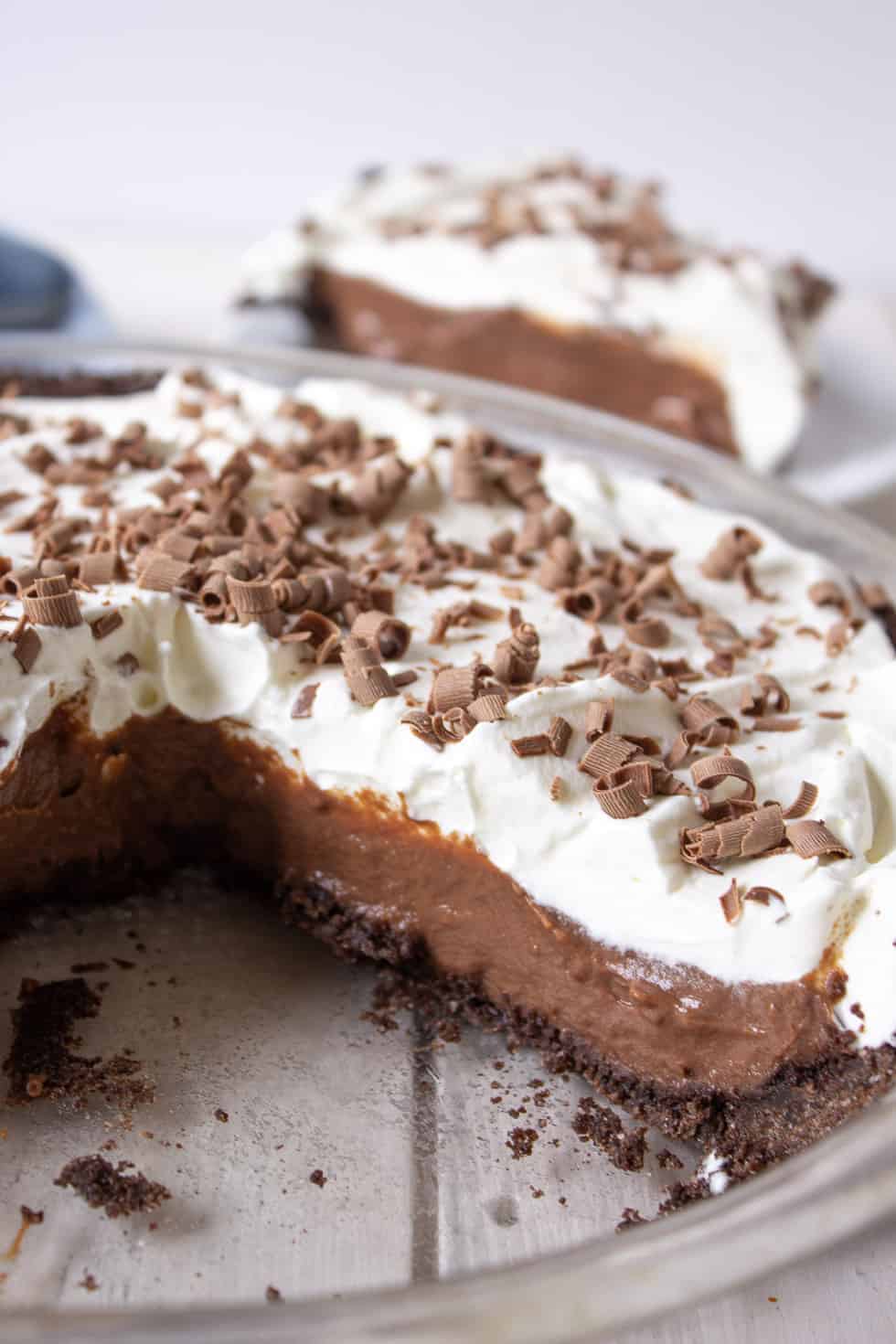 A chocolate pie with slice missing from the pie plate. 