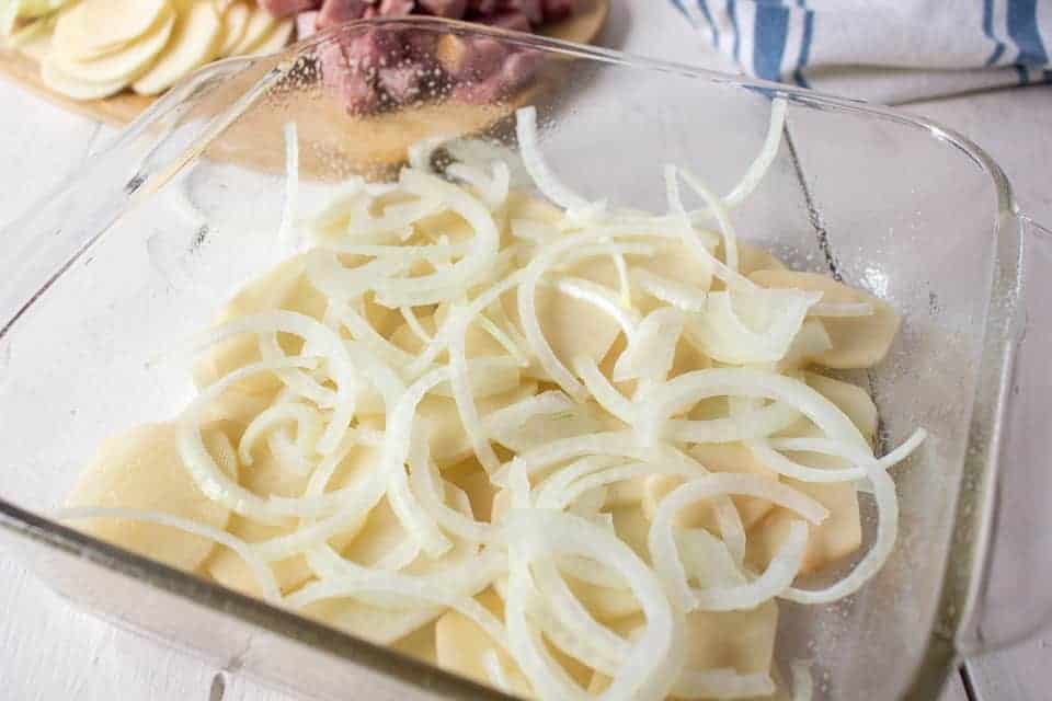 Thinly slice potatoes on top of sliced potatoes.